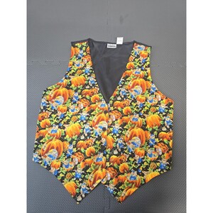 May include: A sleeveless vest featuring a black background with a repeating pattern of orange pumpkins and small blue-clad figures. The garment has a V-neckline, a solid black interior lining, and a front button closure with four visible black buttons.