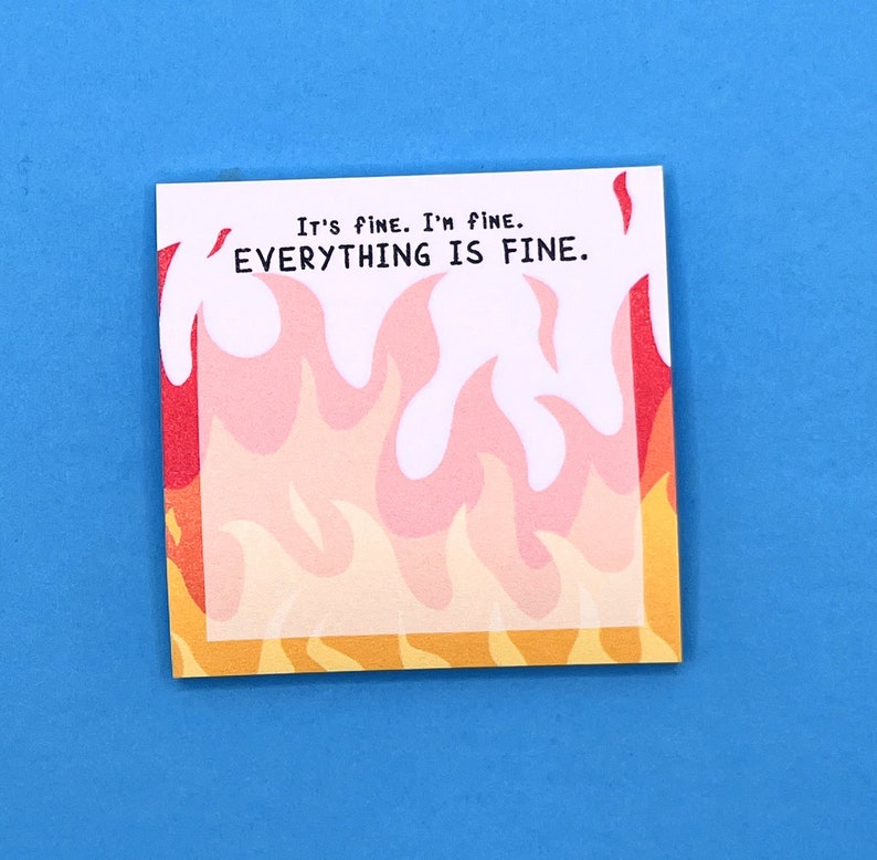 May include: A white square sticky note with the text "It's fine. I'm fine. EVERYTHING IS FINE." in black text. The background of the note is a pattern of orange, yellow, and pink flames.