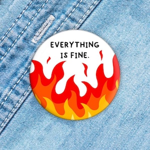 Könnte beinhalten: Ein weißer Knopf mit roten und gelben Flammen und dem Text "EVERYTHING IS FINE."
