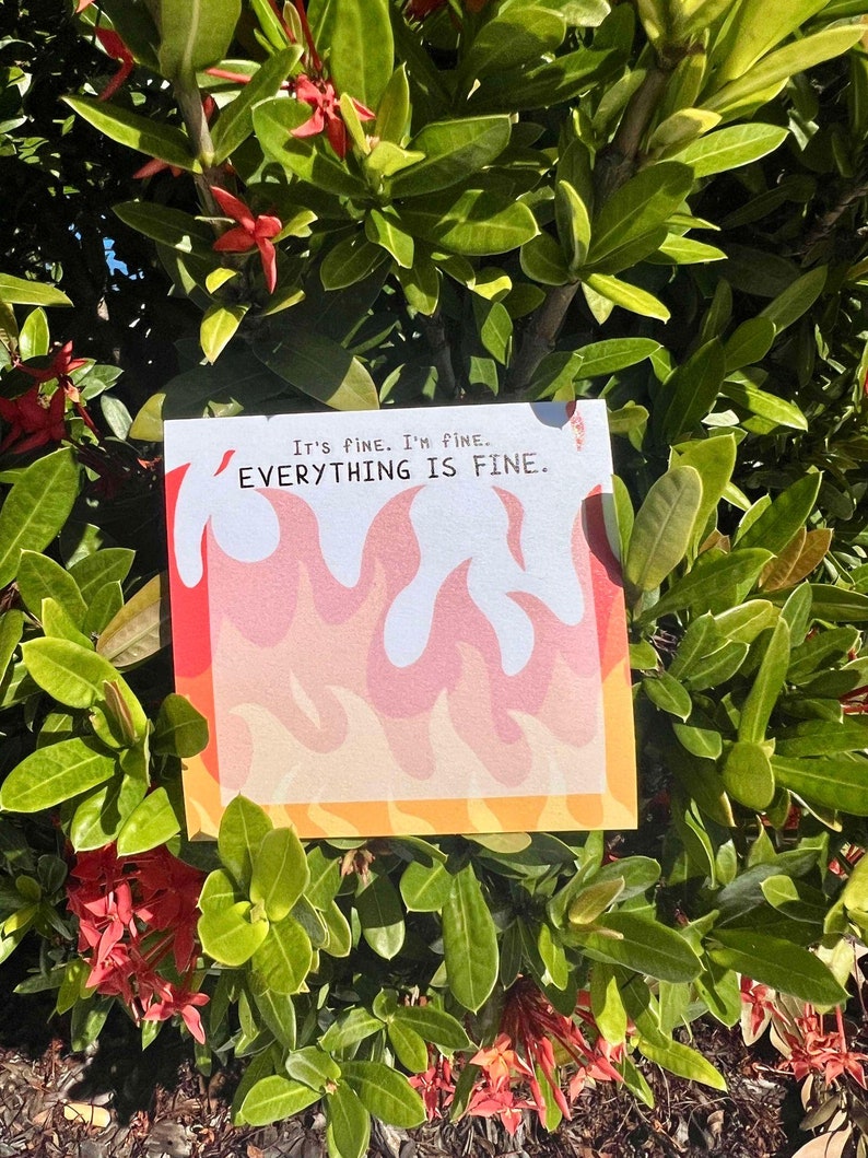 May include: A white card with orange and red flames printed on it. The card has the text "It's fine. I'm fine. EVERYTHING IS FINE." printed on it.