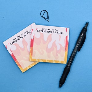May include: Two yellow sticky notes with a fire design and the text "It's fine. I'm fine. Everything is fine." on a blue background.