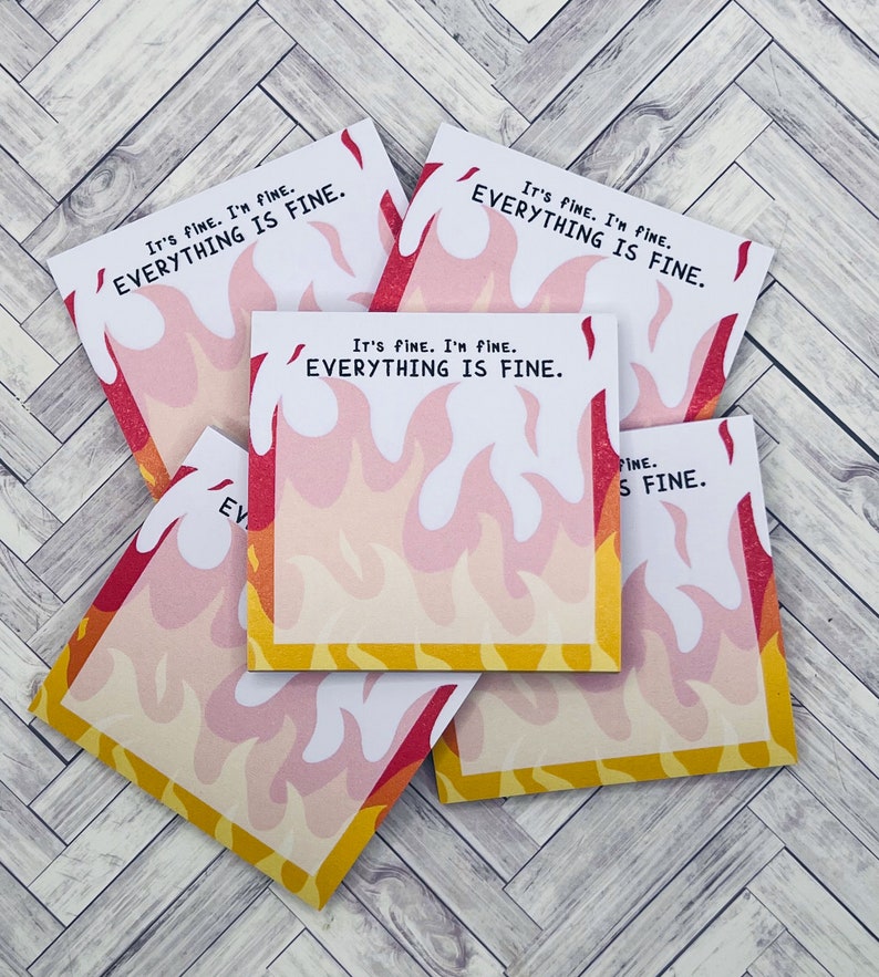 May include: A stack of five sticky notes with a flame design. The notes have the text "It's fine. I'm fine. Everything is fine." printed on them.