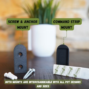 Peut inclure: Deux supports muraux noirs pour suspendre des plantes. Le support de gauche est étiqueté "Screw & Anchor Mount" et le support de droite est étiqueté "Command Strip Mount". Les deux supports sont interchangeables avec tous les modèles et toutes les tailles de pots.