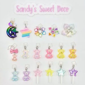 May include: Assortment of colorful charms featuring a rainbow star, a crescent moon, a bow, teddy bears, and star-shaped lollipops.  The charms are made of iridescent plastic and have a variety of colors, including pink, blue, yellow, and green.  The charms are attached to clear plastic rings.