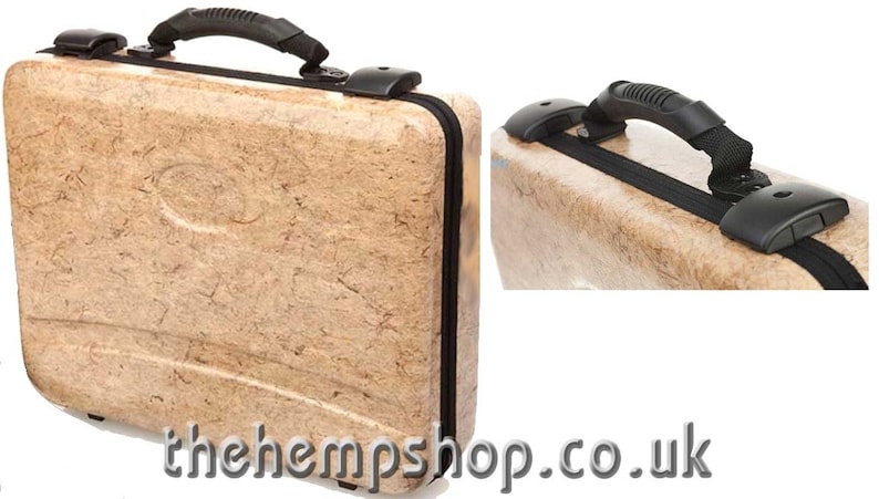 May include: A beige suitcase with a black handle and black accents. The suitcase is made of a textured material that resembles hemp.