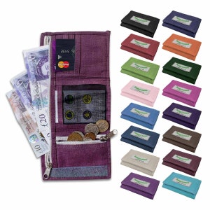 May include: A purple trifold wallet, open to show banknotes, coins, and a credit card. A selection of other wallets in different colours are displayed. Each wallet has a rectangular patch with the text "happiness just smile".