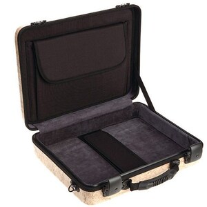 May include: A beige hard-shell case with a black interior and a zippered pocket. The case has a handle and a latch.