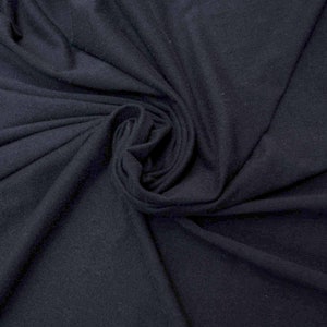 Puede incluir: Primer plano de una tela azul oscuro con una superficie suave y texturizada. La tela está doblada y drapeada, creando un aspecto suave y fluido.