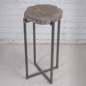 May include: A gray, rustic side table with a natural wood slab top. The table has a metal frame with a cross-base design. The table is approximately 30 inches tall.