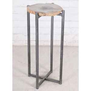 May include: A round, gray agate slice table top with a natural edge sits on a metal stand with a cross-shaped base.