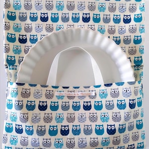 Peut inclure: Un plat à tarte en céramique blanche avec une poignée blanche est à l'intérieur d'un sac en tissu crème. Le sac est orné de motifs de hiboux bleus et gris. Le texte "Les Tendres de la Maîtresse" est imprimé sur le sac.