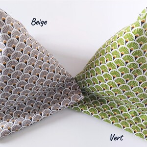 May include: Two fabric book pillows, one beige and one green, are displayed. The beige pillow has a repeating pattern of gray, white, and gold fan shapes. The green pillow has a similar pattern in shades of green and white. The word "Beige" is written on the beige pillow and the word "Vert" is written on the green pillow.
