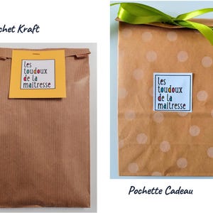 May include: Two brown paper bags. The left bag is plain with a yellow square label reading "les toudoux de la maitresse". The right bag features light polka dots, a green ribbon tie at the top, and a white square label reading "les toudoux de la maitresse".