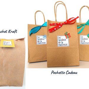 May include: Kraft paper gift bags with paper handles. The bags are decorated with ribbons and stickers. The stickers have the text "Les toudoux de la maitresse". One bag has a blue ribbon, one has a red ribbon, and one has a teal ribbon.