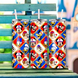 May include: Three stainless steel tumblers with white straws. Each tumbler features a repeating pattern of cartoon characters in sailor outfits, set against a red, white, and blue diamond pattern. The design includes anchors and nautical elements.