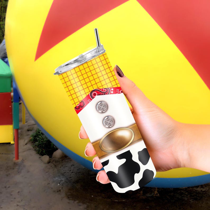 May include: A stainless steel tumbler with a straw, featuring a design inspired by a cowboy. The tumbler has a yellow plaid pattern, a red bandana design, a white shirt design with two silver buttons, and a black and white cowhide pattern.