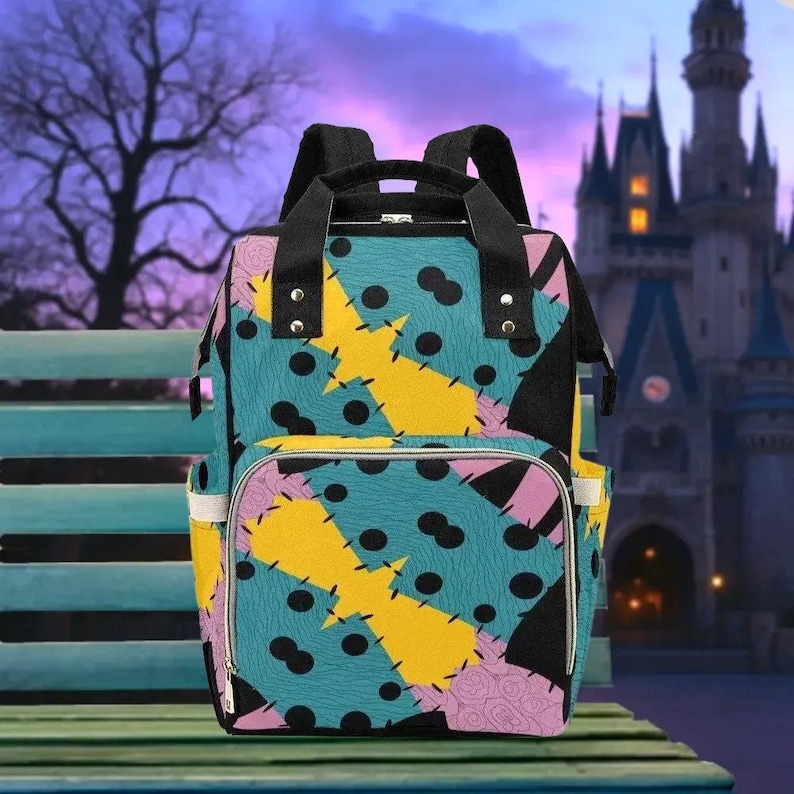 A colorful backpack with a pattern resembling Sally's patchwork design is displayed in front of a castle at night.