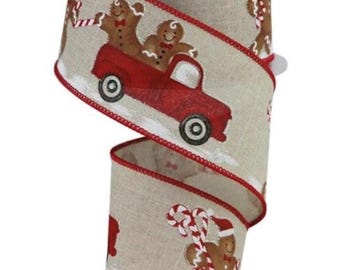 Op de afbeelding: Decoratief kerstlint met een feestelijk ontwerp. Het lint heeft een beige achtergrond met een herhalend patroon van peperkoekmannen, rode vrachtwagens en zuurstokken. De randen zijn afgewerkt met rode stiksels.
