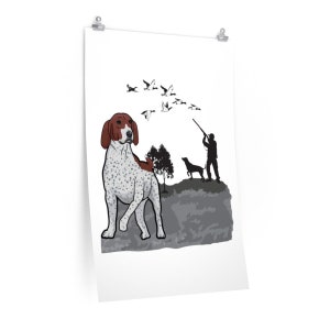 May include: A white and brown spotted dog stands in a field with a hunter and a dog in the background. The dog is looking up at a flock of geese flying overhead.