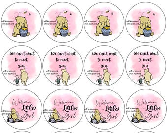 May include: Circular stickers with Winnie the Pooh illustrations and text. Designs include "Welcome Little Girl," "We can't wait to meet you," and "Oh Baby." The stickers feature pink watercolor backgrounds and honey pots.