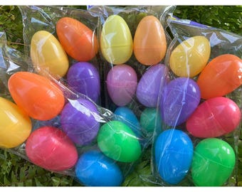 May include: A collection of plastic Easter eggs in various colors, including yellow, orange, red, pink, purple, blue, and green. The eggs are arranged in a random pattern and are ready for filling with treats.