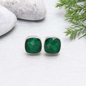 May include: A pair of silver earrings with square green gemstone settings.