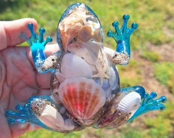 Figura decorativa de rana con temática de playa y conchas marinas, hecha a mano en resina.