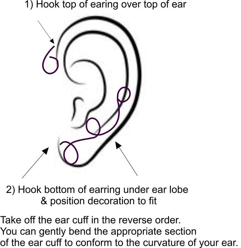 May include: A black and white illustration showing how to wear an ear cuff. The illustration shows a side view of an ear with a black ear cuff wrapped around the upper part of the ear. The text in the image reads: "1) Hook top of earing over top of ear" and "2) Hook bottom of earring under ear lobe & position decoration to fit".