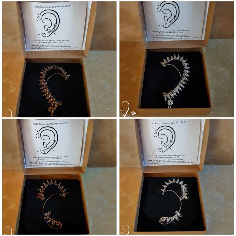 May include: Four open boxes with instructions on how to wear an ear cuff. Each box contains a silver or gold ear cuff with a decorative design. The ear cuffs are made of metal and have a hook at the top to secure them to the ear.