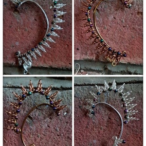 May include: Four ear cuffs made of wire and beads. Two are silver with iridescent beads and two are copper with iridescent beads.