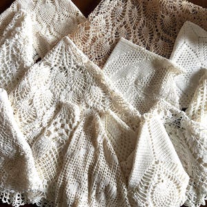 Puede incluir: Una colección de tapetes de ganchillo en tonos crema y blanco roto con varios patrones intrincados, incluyendo motivos de piña, rejillas geométricas y diseños calados inspirados en flores, superpuestos para mostrar sus texturas.
