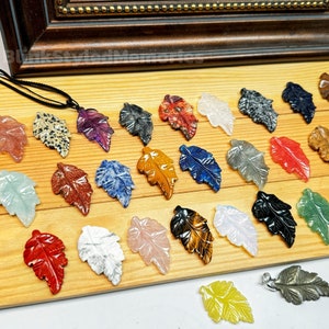 May include: A collection of 25 gemstone leaf pendants in various colors and patterns, including red, green, blue, purple, and brown. The pendants are made of natural stones and are perfect for jewelry making.