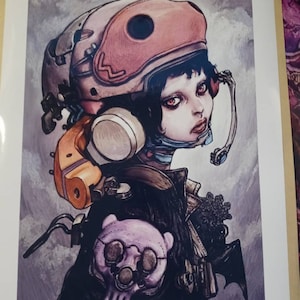 May include: A colorful illustration of a young woman wearing a helmet and a futuristic outfit. The woman has red eyes and a serious expression. The background is a cloudy sky with a hint of water in the distance. The text "Artist: Katsuya Terada" is at the bottom of the image.