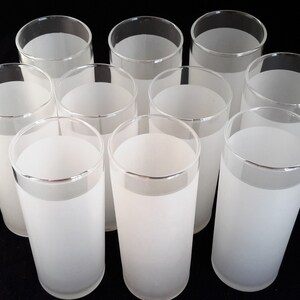 May include: Set of ten frosted glass tumblers. The glasses are clear with a frosted white band around the top.