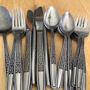 May include: A set of silverware with a floral pattern on the handles. The set includes spoons, forks, and knives.
