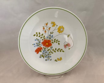 Puede incluir: Un plato de cena de cerámica blanca con un borde verde y un diseño floral con flores naranja, rojo, amarillo y azul.