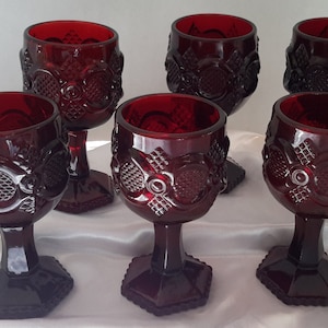 Puede incluir: Juego de seis copas de vino de vidrio rojo rubí con un diseño texturizado. Las copas tienen una copa redonda y una base hexagonal.