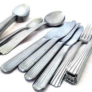 Könnte beinhalten: Ein Set aus drei Keramikbechern mit gesprenkelter, matter Oberfläche. Die Becher sind in Creme-, Hellgrau- und Dunkelgrautönen gehalten. Jeder Becher hat ein schlichtes, minimalistisches Design, ideal für Kaffee oder Tee.