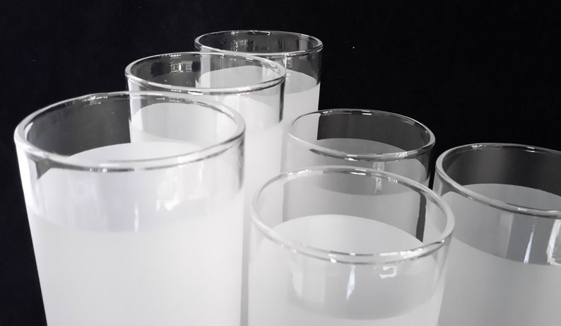 May include: Six frosted glass tumblers with a white frosted finish. The glasses are stacked in a pyramid shape.