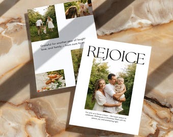 Op de afbeelding: Twee witte wenskaarten met familiefoto's en tekst. Eén kaart leest "REJOICE" met een familiefoto. De andere kaart heeft een foto en tekst die luidt "Dankbaar voor weer een jaar van lachen, liefde en familie".