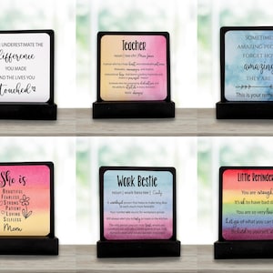 May include: Six decorative wooden plaques with motivational quotes and definitions. Each plaque has a black base and a colourful top with text. The plaques are designed for display on a desk or shelf.