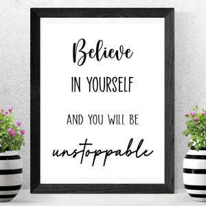 K&ouml;nnte beinhalten: Ein gerahmter Druck mit den Worten "Believe in Yourself and You Will Be Unstoppable" in schwarzer Schrift. Zwei dekorative Vasen mit schwarz-wei&szlig;en Streifen und kleinen rosa Blumen flankieren den gerahmten Druck.