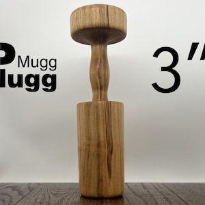 May include: A wooden mallet with a 3" diameter head and a handle. The mallet is made of light brown wood with dark brown streaks.