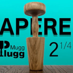 May include: A wooden tapered  2 1/4"  mugger, a tool used for crushing ingredients, with a light brown wood grain. The mugger is sitting on a wooden surface. The text "TAPERED" and "Mugg Ilugg" are visible in the background.