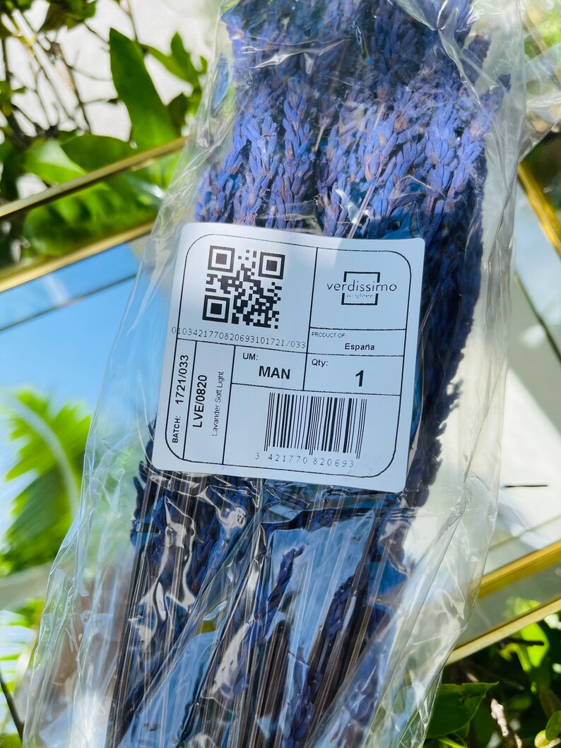 May include: A clear plastic bag containing a bunch of dried lavender flowers. The bag has a label with the text "verdissimo", "PRODUCT OF", "Espa&ntilde;a", "BATCH: 1721/033", "LVE/0820", "Lavander Soft Light", "UM: MAN", "Qty: 1", and a barcode.