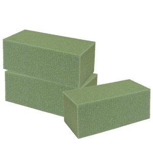 May include: Three green rectangular blocks of floral foam for arranging flowers.