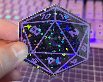 May include: A purple iridescent holographic sticker of a 20-sided die with numbers 2, 4, 6, 8, 10, 12, and 18 visible. The die is covered in a glittery pattern of stars.