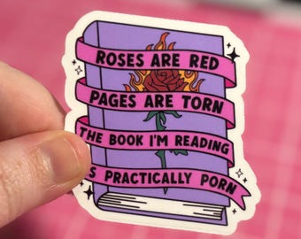 May include: A sticker featuring a purple book with the text "Roses are red, pages are torn, the book I'm reading is practically porn." A rose is in flames on the cover.