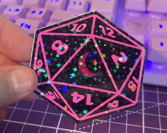 May include: A black and pink iridescent holographic sticker of a 20-sided die with a crescent moon and stars. The die has numbers 10, 12, 2, 8, 14, 6, and 19.