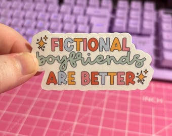 May include: A sticker with the text "Fictional boyfriends are better" in rainbow colors with stars on either side.